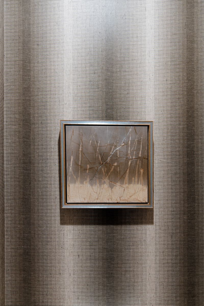 A framed abstract artwork in Johnston hung on a textured grasscloth wall in warm taupe and cream.