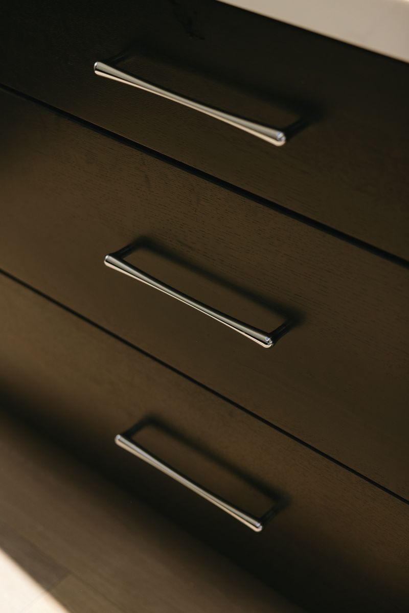 Dark stained oak cabinetry in West Des Moines with slim polished chrome drawer pulls.