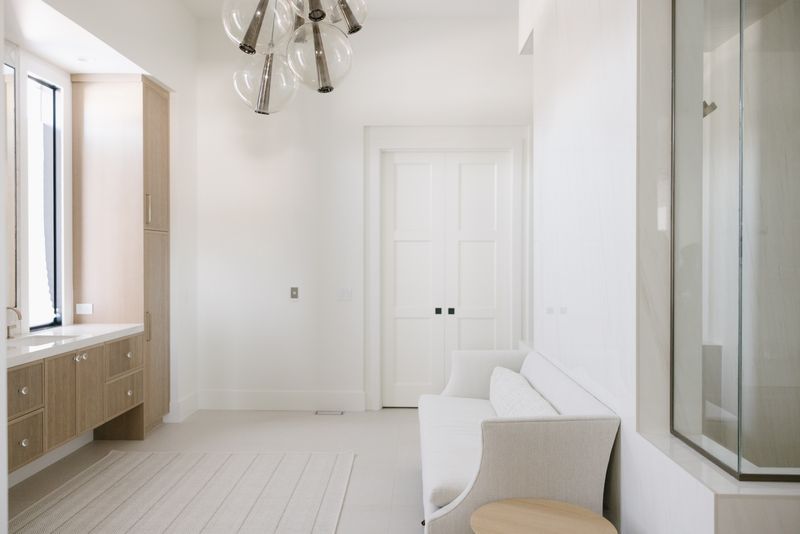 A primary bath in West Des Moines with a fluted white oak vanity under a white quartz counter.