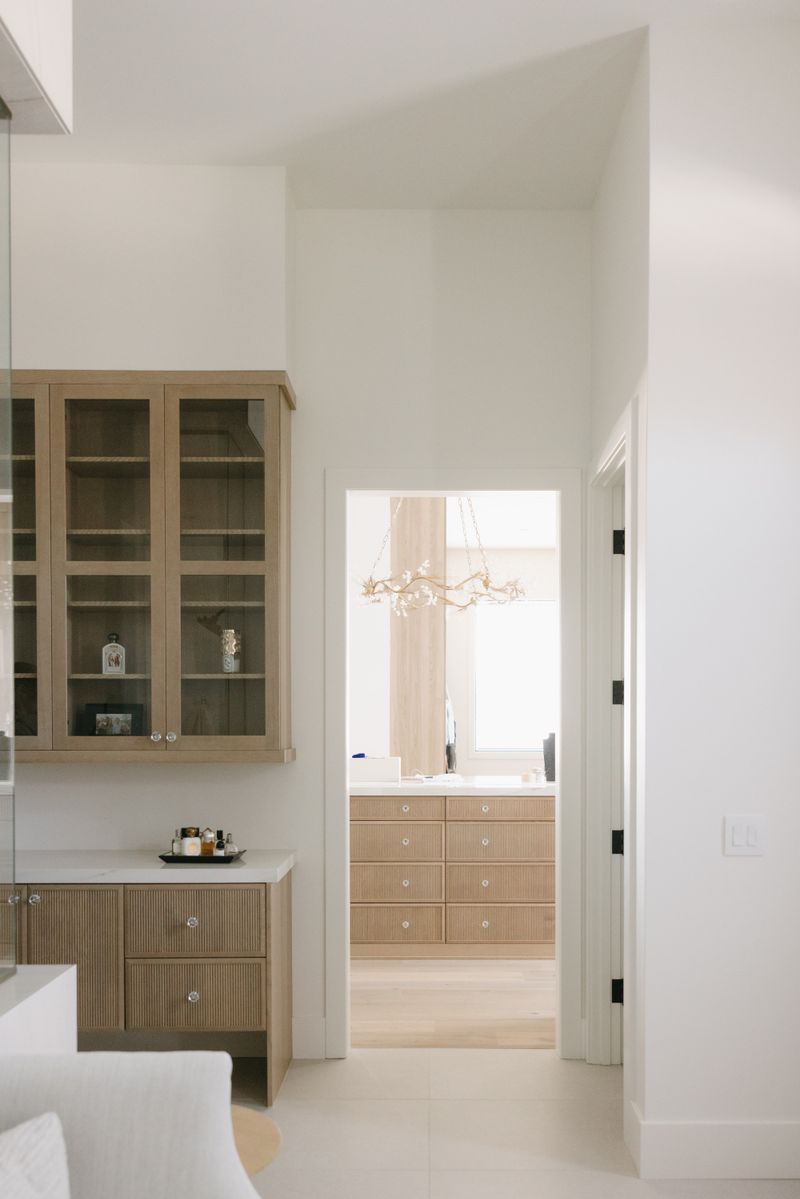 A primary bath in West Des Moines with fluted white oak vanity cabinets and glass knobs under a white quartz counter.