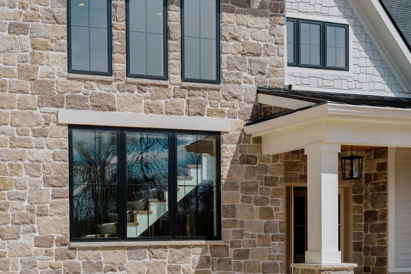 A stone exterior in Van Meter with a black lantern hanging over the white porch column.