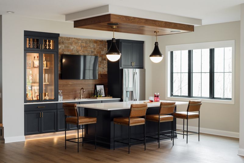 A kitchen in Van Meter with a black island and white quartz counter under a walnut plank ceiling.