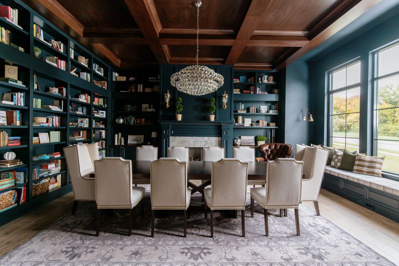 A deep teal dining room in Urbandale with a dark walnut coffered ceiling over a long wood table.