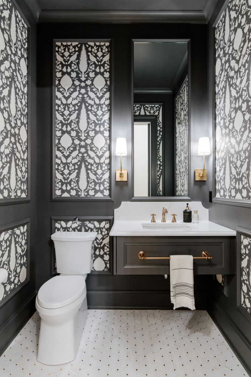 A black and white powder room in Urbandale with paneled floral wallpaper above a floating charcoal vanity.