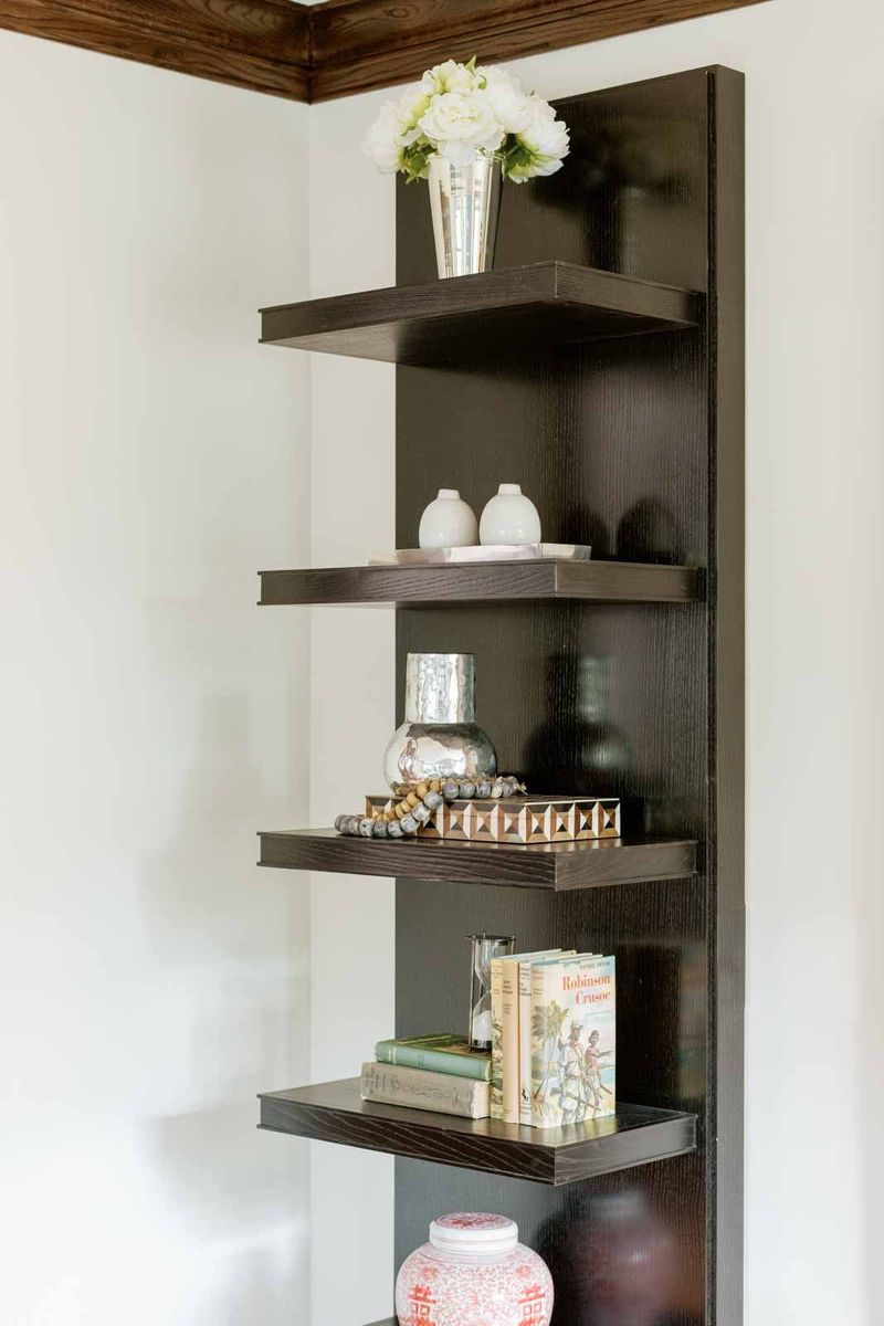 A living room in Des Moines with black stained oak built-in shelves against a white wall.