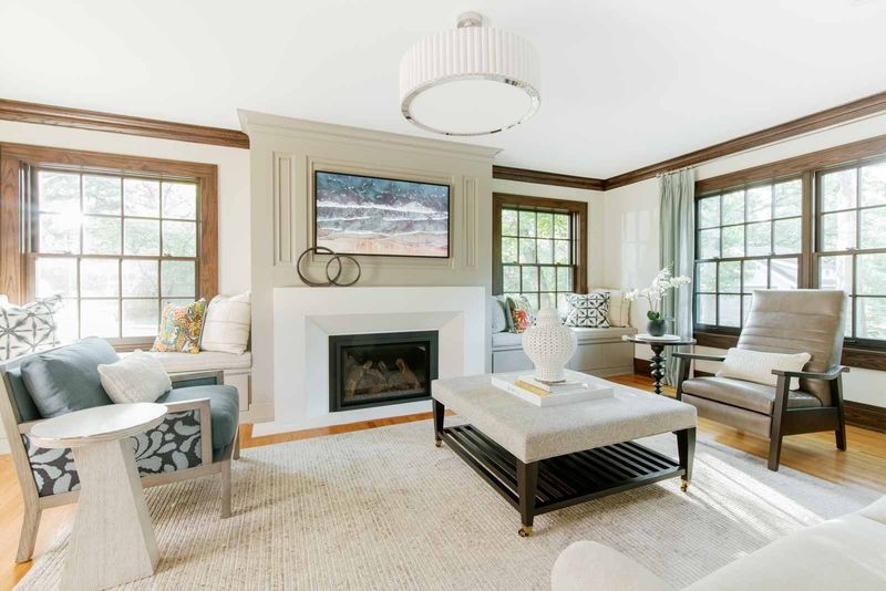 A living room in Des Moines with a taupe leather lounge chair beside dark stained wood window trim.