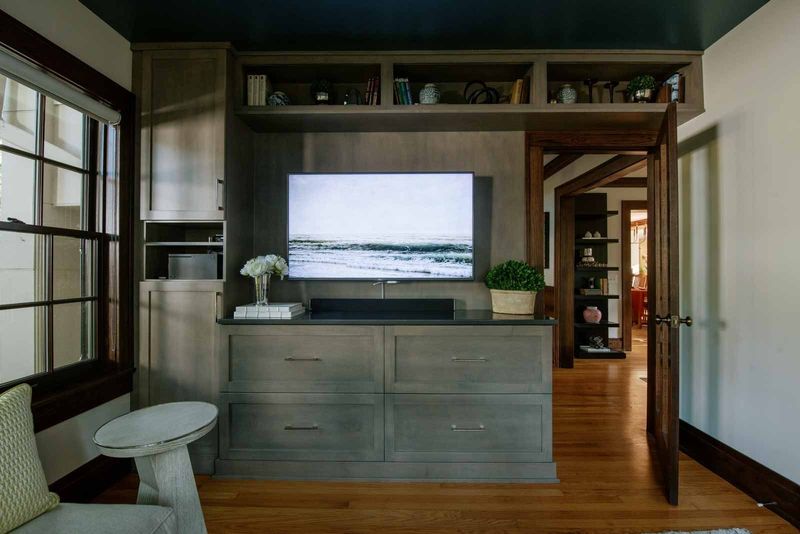 A living room in Des Moines with gray stained built-in cabinets under a glossy deep teal ceiling.