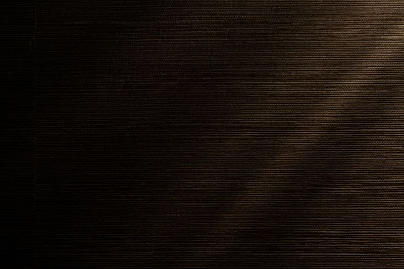 Dark brown grasscloth wallcovering in West Des Moines, with fine bronze threads woven through the weave.