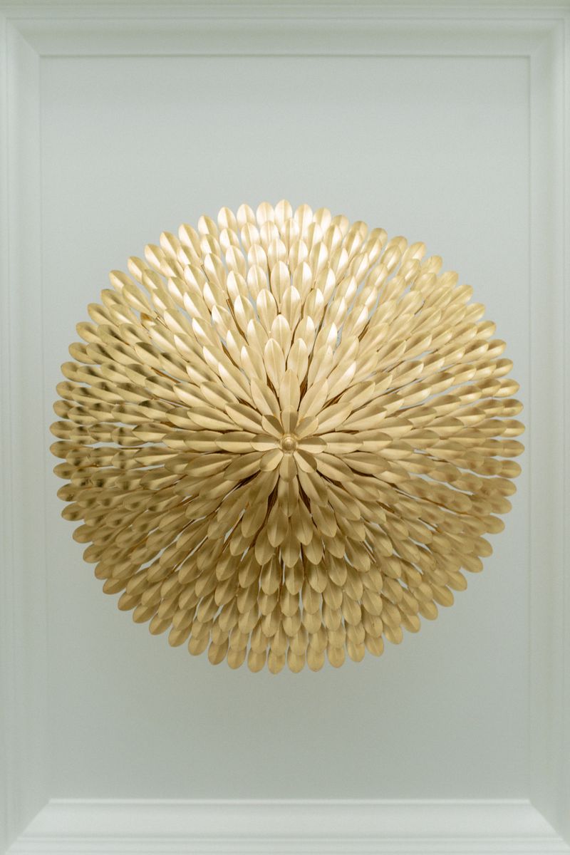 A gold leaf flush mount light on a soft white trayed ceiling in Des Moines.