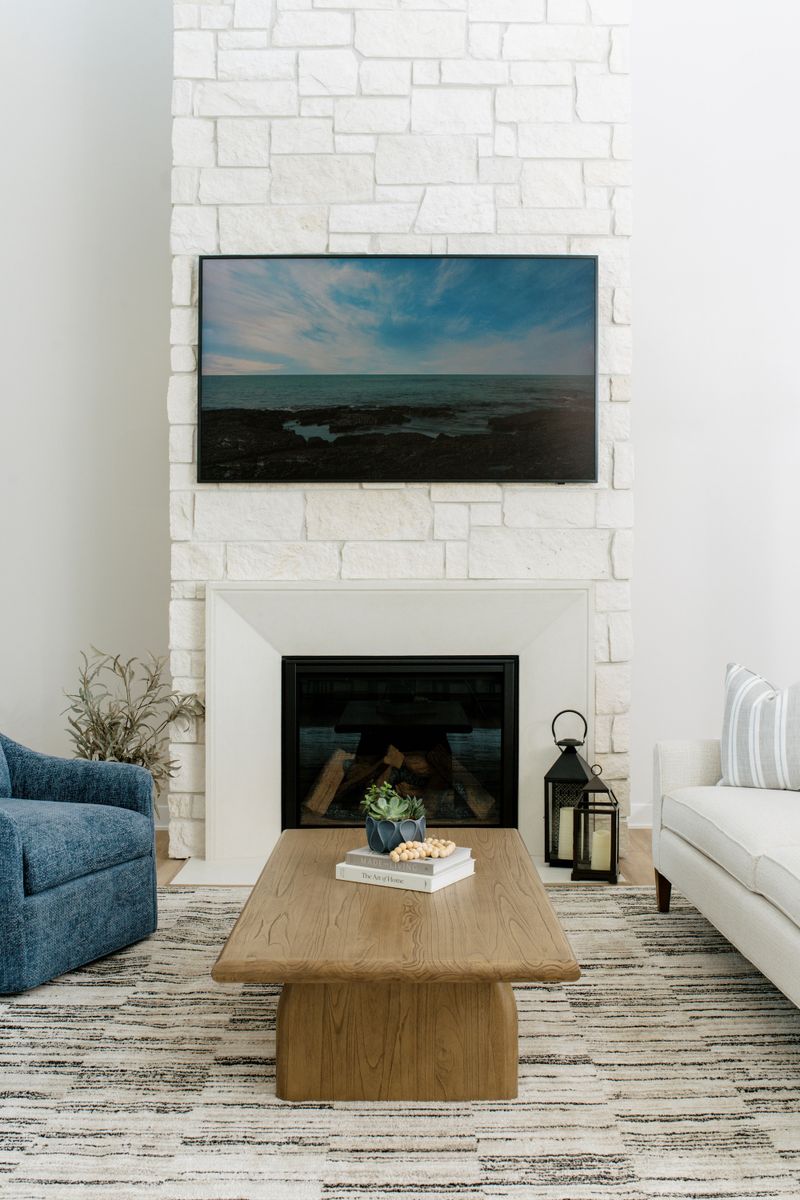 A living room in Clive with a white stone fireplace wall and a limestone surround running to the ceiling.
