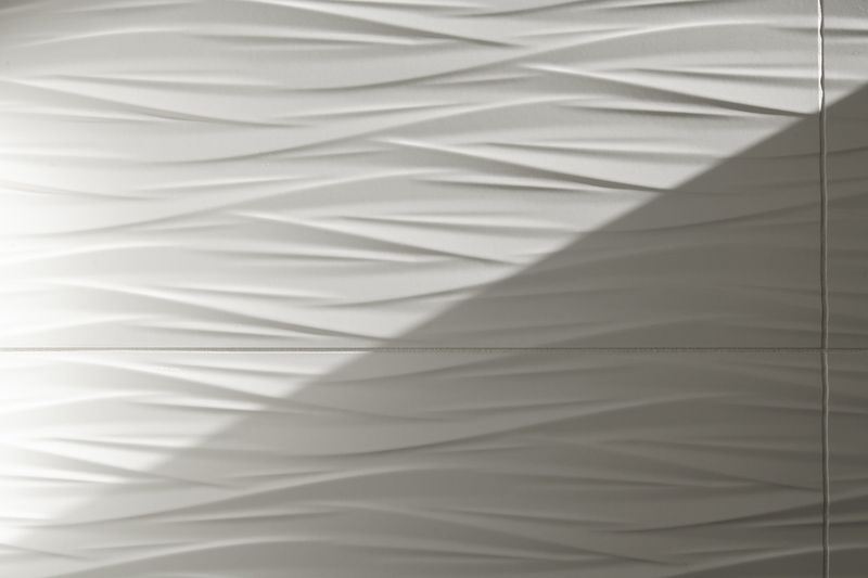 White wave textured ceramic wall tile in Des Moines, with thin matching grout lines between large square tiles.